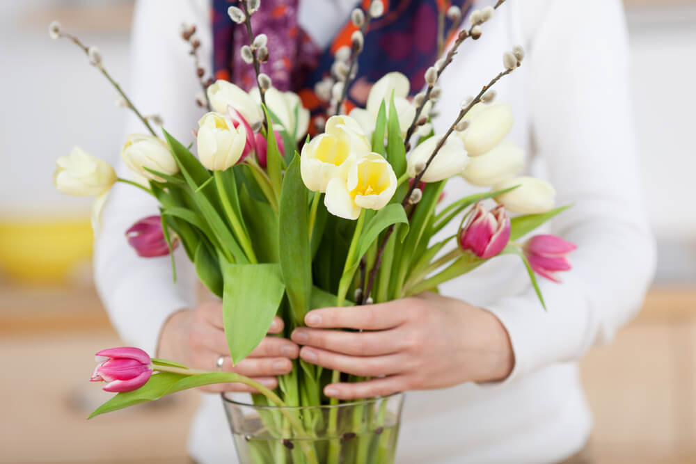 Woman putting flowers into vase