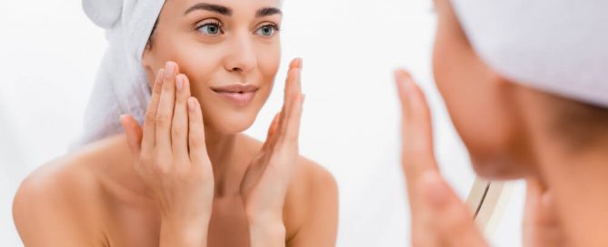 Woman looking at exfoliated skin in mirror