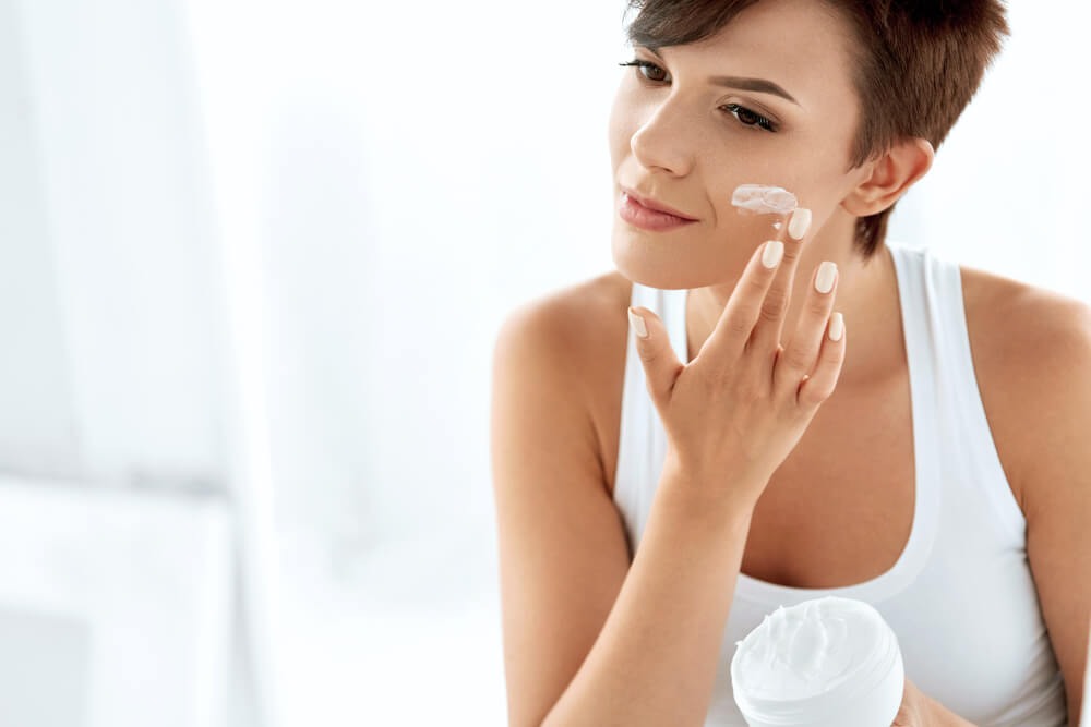 Woman applying face cream