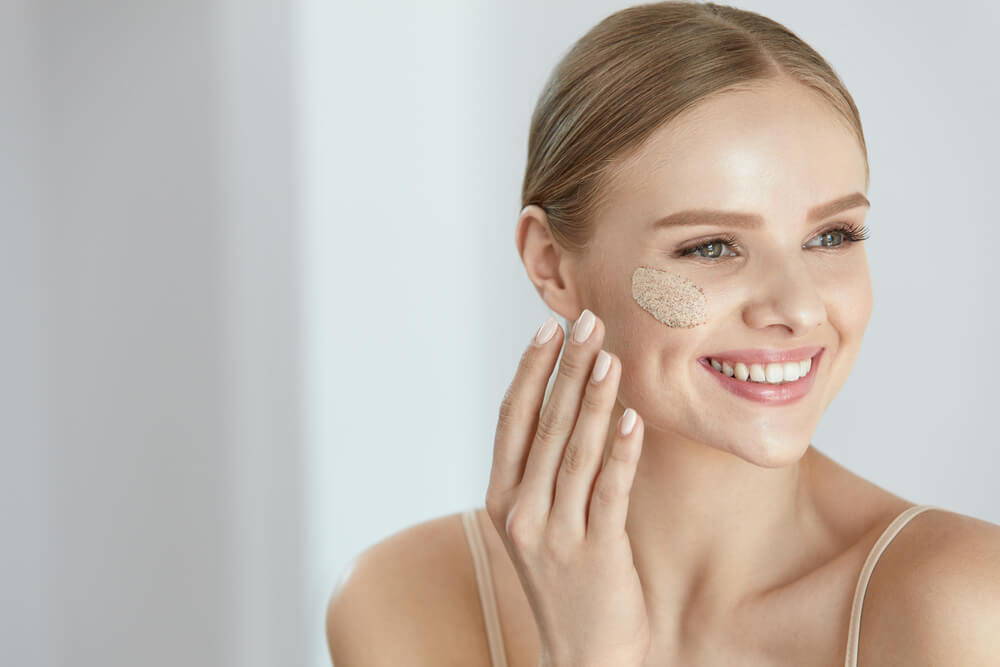 Woman applying face scrub