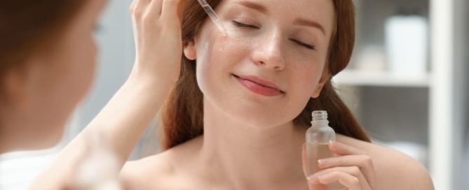 Woman applying hydrating serum to face