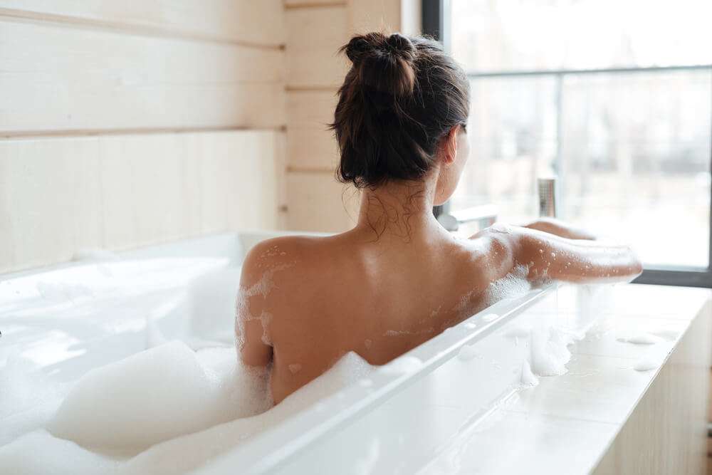 Woman taking bath to de-stress for your skin