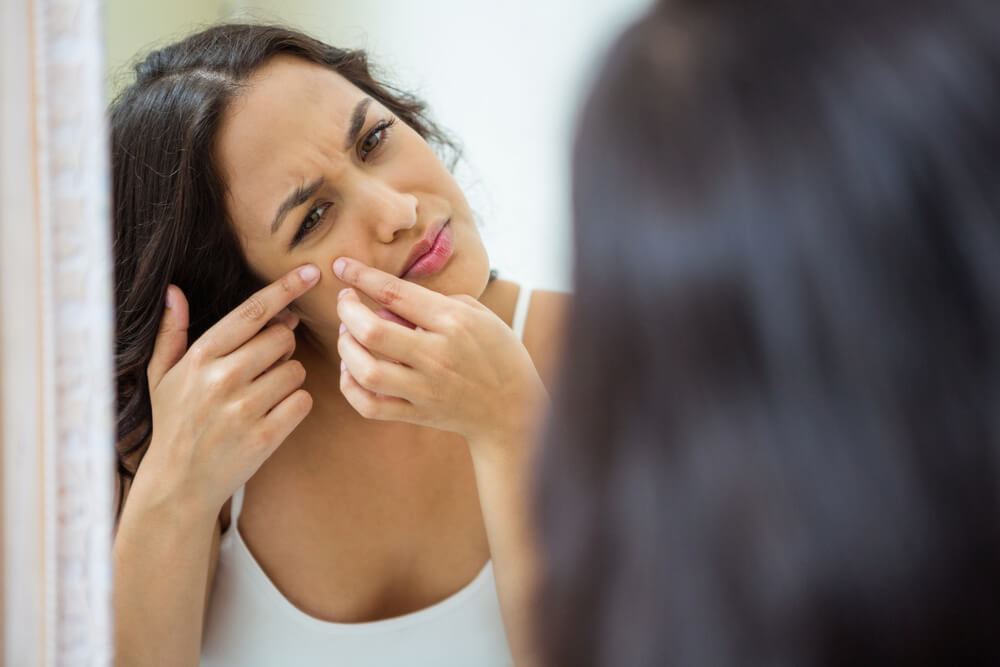 Woman popping a pimple