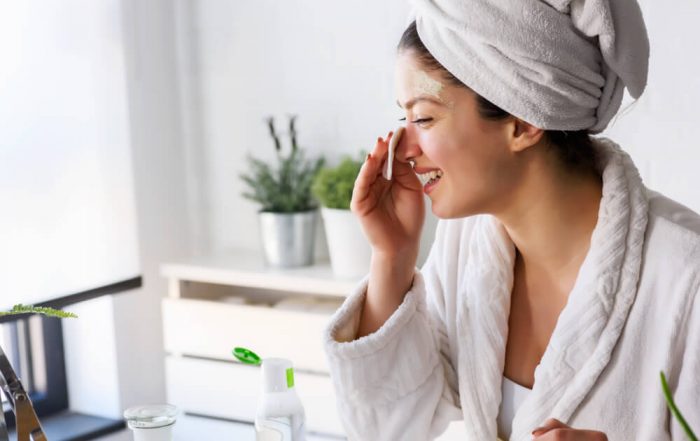 Woman using face mask after reading our new year's resolutions for your skin