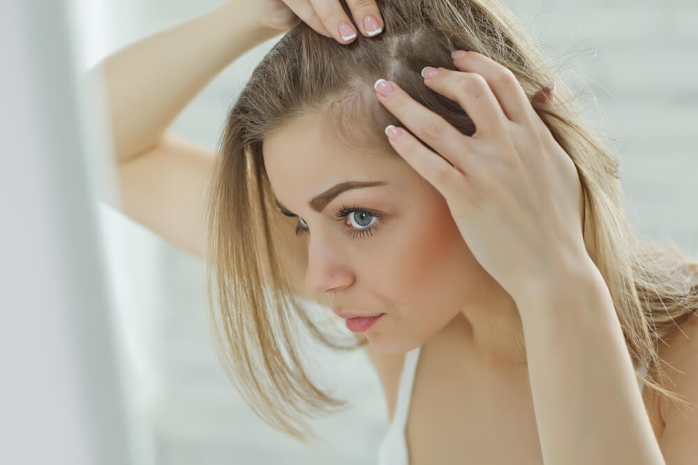 Woman looking at hair after following the no poo, no wash trend