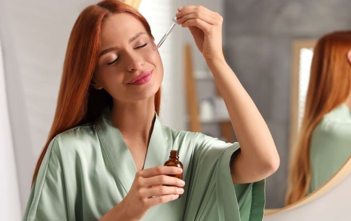 Woman applying serum to face